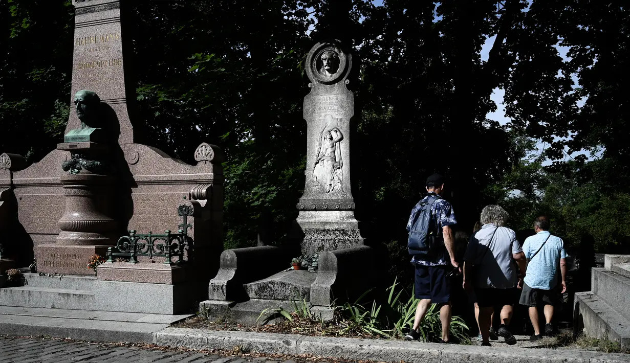 Turis mengunjungi pemakaman Pere Lachaise di Paris (22/7/2019). Pemakaman ini dikenal di seluruh dunia sebagai tempat peristirahatan orang-orang terkenal dari berbagai kalangan, mulai dari seniman, bintang film, musisi, politisi, pelukis, penulis, sampai ilmuwan. (AFP Photo/Philippe Lopez)