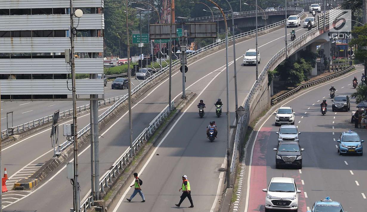 Kendaraan melintas di Jalan Gatot Soebroto di Jakarta, Selasa (1/5). Peringatan Hari Buruh menyebabkan lalu lintas di sejumlah ruas jalan Ibukota menjadi lebih lengang dibanding hari biasa. (Liputan6.com/Immanuel Antonius)