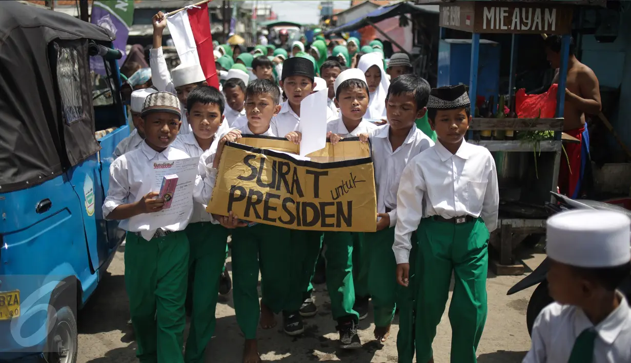 Murid Madrasah Ibtidayah (MI) Yayasan Nurul Bahri melakukan pawai usai menulis surat untuk Presiden Jokowi, di perkampungan nelayan Muara Angke, Jakarta, Senin (27/2). Gerakan Ayo Menulis ini digagas Standarpen Industries. (Liputan6.com/Faizal Fanani)