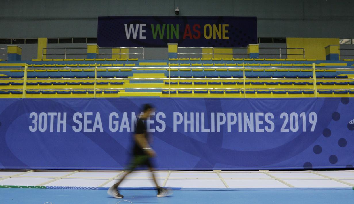 Seseorang melintas tribun venue bulutangkis SEA Games 2019 di Muntinlupa Sports Center, Manila, Sabtu (23/11). Cabang bulutangkis akan mulai bertanding pada Minggu (1/12). (Bola.com/M Iqbal Ichsan)