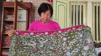 Penerus bisnis batik peranakan Cirebon, Indrawati atau akrab disapa Giok menunjukkan keunikan batik peranakan dengan batik trusmian. Foto (Liputan6.com / Panji Prayitno)