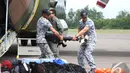 Militer Singapura membantu menurunkan barang bantuan dari pesawat, Pangkalan Bun, Kalteng, Kamis (1/1/2015). (Liputan6.com/Herman Zakharia)
