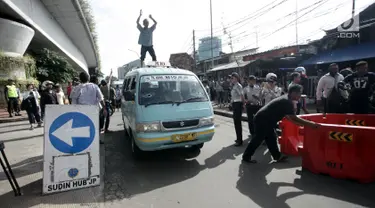 Sopir angkot berunjuk rasa dengan menaiki kendaraannya di Jalan Jatibaru, Tanah Abang, Jakarta, Senin (29/1). Mereka menolak penutupan Jalan Jatibaru dan menuntut Pemprov DKI Jakarta segera membuka kembali jalan tersebut. (Liputan6.com/Arya Manggala)