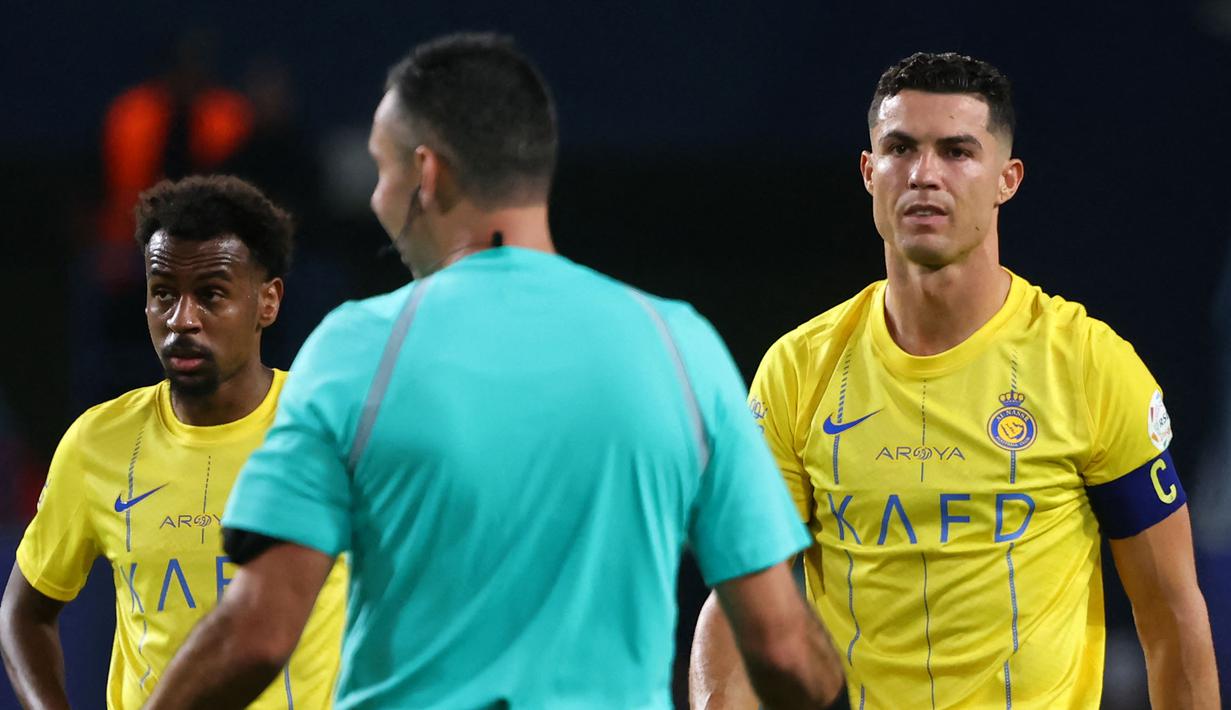 Ekspresi kecewa pemain Al-Nassr, Cristiano Ronaldo (kanan) saat timnya ditahan imbang 2-2 oleh Abha pada laga lanjutan Liga Arab Saudi yang berlangsung di King Saud University Stadium, Riyadh, Arab Saudi, Jumat (06/10/2023) malam WIB. Al-Nassr kini menempati peringkat tiga klasemen dengan raihan 19 poin. (AFP/Fayez Nureldine)