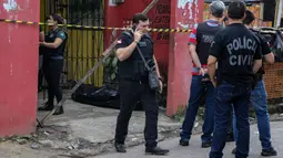 Sejumlah petugas mengecek bar usai penembakan massal di kota Belm, negara bagian utara Par, Brazil (19/5/2019). Sebanyak 11 orang dilaporkan tewas dalam serangan yang dilakukan 7 pria bersenjata tersebut. (Claudio Pinheiro/Agencia Panamazonica/AFP)
