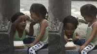 Dua bocah tunawisma sedang berbagi makanan