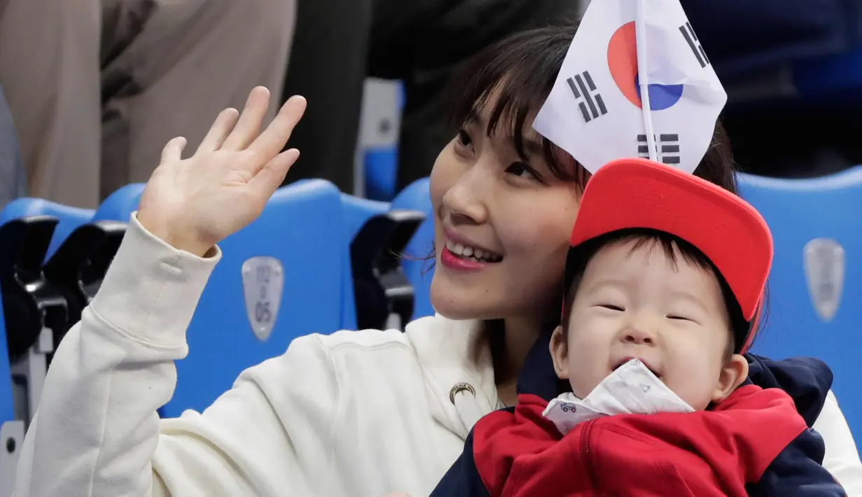 Penggemar wanita Korea Selatan menantikan dimulainya pertandingan speedskating 500 meter putri selama Olimpiade Musim Dingin 2018 di Gangneung, Korea Selatan, Selasa, (13/2). (AP Photo / Julie Jacobson)