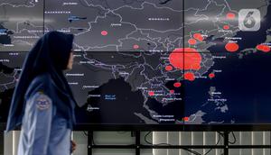 Petugas melewati layar pemantau yang menunjukan penyebaran virus corona (COVID-19) di Dinas Kesehatan DKI Jakarta, Senin (9/3/2020). Dari 3.580 orang yang menghubungi Posko COVID-19 DKI Jakarta, ada 64 kasus kategori Orang Dalam Pantauan dan 56 Pasien Dalam Pengawasan. (Liputan6.com/Faizal Fanani)