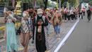 Sejumlah orang yang mengenakan batik mengambil gambar menggunakan gadgetnya saat berjalan di catwalk sepanjang Jalan Jenderal Sudirman, Jakarta, Minggu (2/10/2022). Kegiatan yang diikuti ratusan orang ini diselenggarakan oleh Bank Mandiri untuk menyambut Hari Batik Nasional yang jatuh setiap tanggal 2 Oktober 2022. (Liputan6.com/Faizal Fanani)