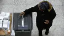 Seorang pria memasukkan surat suara ke tempat sampah yang disulap menjadi kotak suara saat pemilihan umum Belanda di sebuah TPS di Den Haag, Rabu (15/3). Pemilu ini untuk menentukan siapa perdana menteri Belanda selanjutnya (JOHN THYS/AFP)
