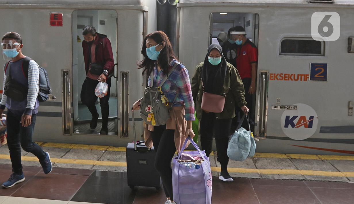 Penumpang kereta api Dharmawangsa Surabaya Pasarturi–Pasar Senen tiba di stasiun Senen, Jakarta, Minggu (3/01/2021). PT KAI Daop 1 memperkirakan sekitar 15.000 - 16.000 lebih penumpang KA Jarak Jauh turun di area Daop 1 Jakarta dari wilayah Jabar, Jateng dan Jatim. (Liputan6.com/Herman Zakharia)