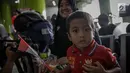 Seorang anak menunjukan pin garuda di Stasiun Gambir, Jakarta, Kamis (1/6). Dalam rangka memperingati HUT Pancasila PT KAI Daop 1 memberikan pin dan bendera merah putih kepada penumpang kereta api. (Liputan6.com/Faizal Fanani)