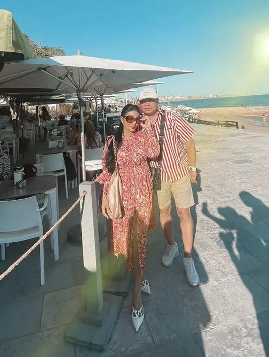 Romantis bersama suaminya, Krisdayanti mengenakan dress lengan panjang warna merah yang memiliki detail bunga-bungannya. [@krisdayantilemos]