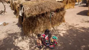 Nybol Madut duduk bersama anak-anaknya di tempat penampungan di Sudan Selatan (22/11). Mereka menderita krisis air bersih dan kelaparan karena minimnya persediaan pangan. (AFP Photo/Albert Gonzalez Farran)