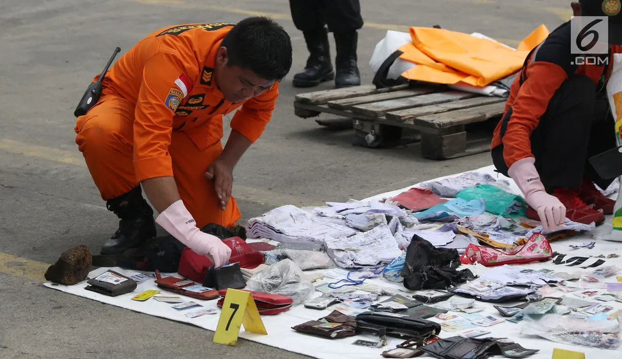 Petugas mengecek dan mengidentifikasi barang temuan yang diduga milik penumpang pesawat Lion Air JT 610 di Pelabuhan JICT 2, Jakarta, Selasa (30/10). Sebelumnya, pesawat Lion Air JT-610 jatuh diperairan Kerawang. (Liputan6.com/Helmi Fithriansyah)