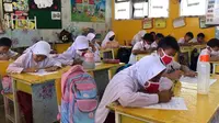 Murid SD diwajibkan memakai masker saat belajar di sekolah karena kabut asap hasil kebakaran lahan. (Liputan6.com/M Syukur)