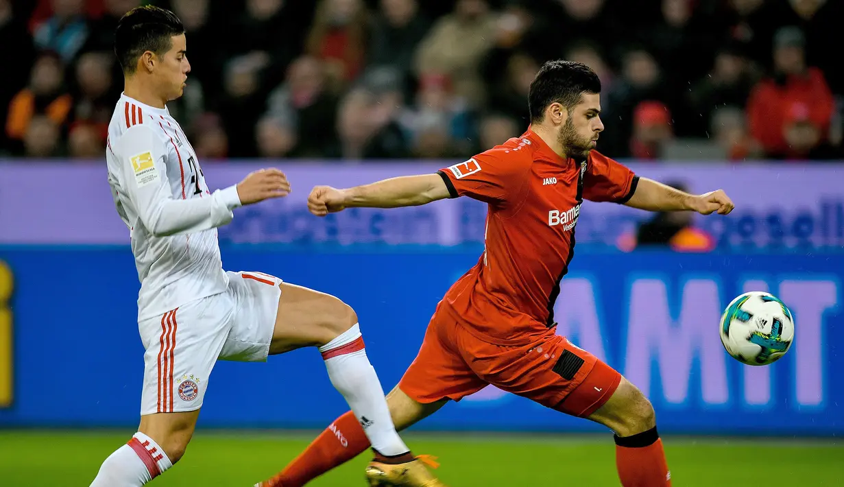 Aksi pemain Leverkusen, Kevin Volland melepaskan umpan saat dibayangi pemain Bayern Munchen, James Rodriguez (kiri) pada lanjutan Budesliga di Bay Arena, Laverkusen, (12/1/2018). Bayern Munchen menang 3-1. (AFP/Sascha Schuermann)