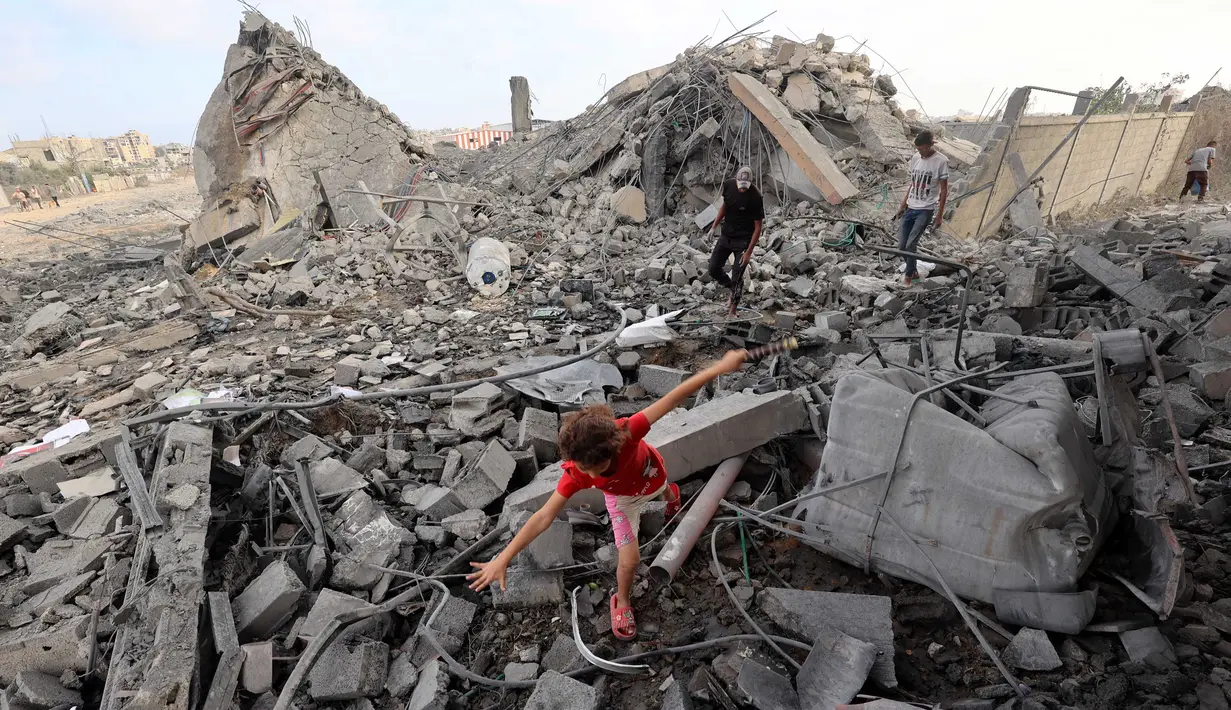 Seorang anak perempuan Palestina mencari jalan di antara reruntuhan bangunan yang dihantam serangan Israel di kamp pengungsi Bureij, Jalur Gaza tengah pada 10 Juli 2025. (Eyad BABA/AFP)