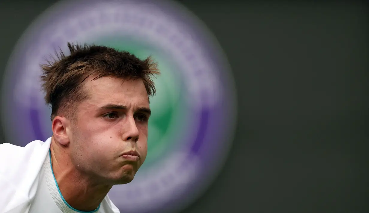 Ekspresi petenis asal Inggris, Arthur Fery, saat melawan petenis asal Rusia, Daniil Medvedev, dalam pertandingan hari ketiga tunggal putra Turnamen Wimbledon 2023 yang berlangsung di The All England Tennis Club, London, Rabu (5/7/2023). (AFP/Adrian Dennis)