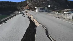 Retakan besar terlihat di jalan dekat pusat gempa, di distrik Pazarcik, kota Kahramanmaras, Turki pada Kamis 16 Februari 2023 setelah terjadinya gempa berkekuatan 7,8 magnitudo menghantam beberapa wilayah di Turki dan Suriah pada 6 Februari lalu. (OZAN KOSE/AFP)