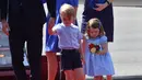 Pangeran George dan adiknya, Putri Charlotte setibanya di Bandara Tegel bersama Pangeran William dan Kate Middleton di Berlin, Rabu (19/7). Charlotte mengenakan gaun floral warna biru dan pita besar di rambutnya. (Bernd Von Jutrczenka/dpa via AP)