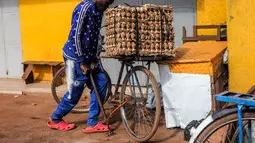 Seorang pria memompa ban sepedanya di Kampala, ibu kota Uganda (30/6/2020). Warga Uganda kini beralih menggunakan sepeda sebagai sarana transportasi yang mendukung di tengah pandemi COVID-19. (Xinhua/Hajarah Nalwadda)