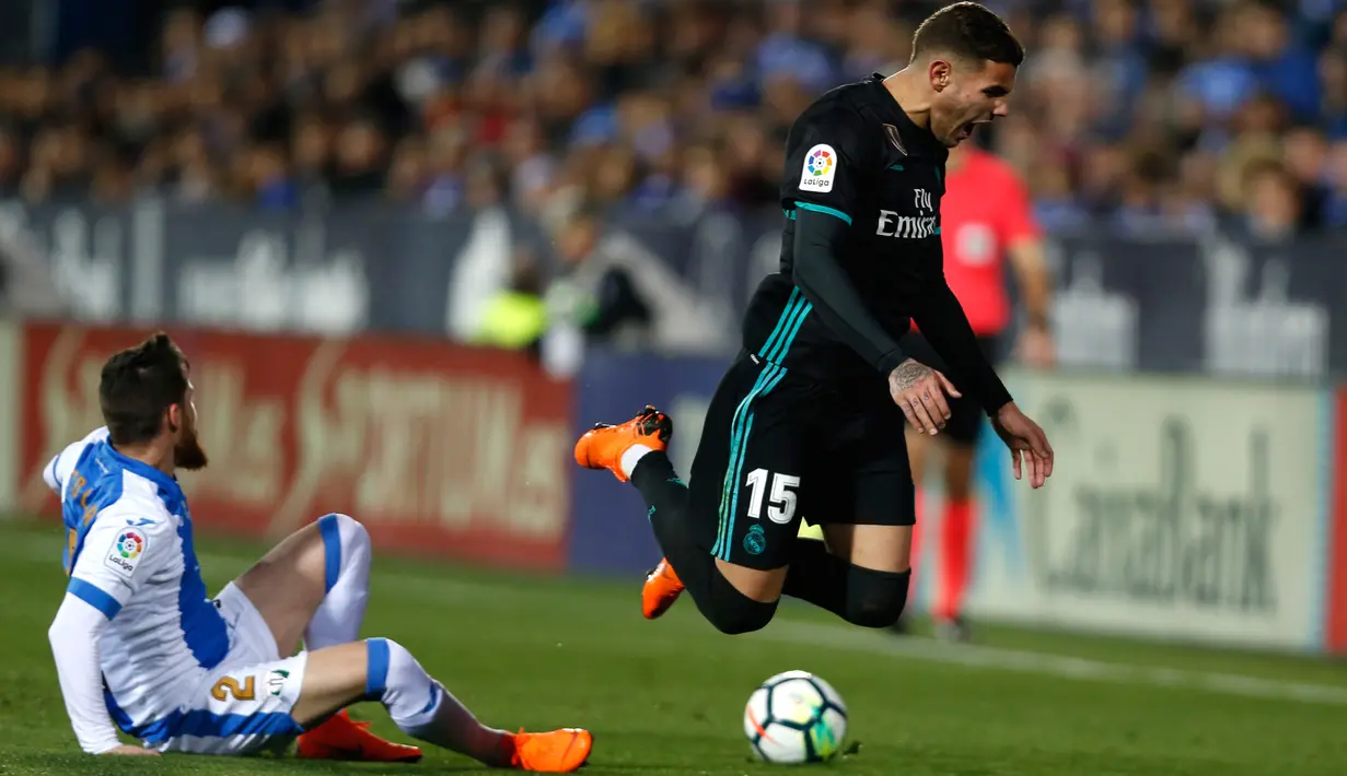 Pemain Real Madrid, Theo Hernandez berebut bola dengan pemain Leganes, Roberto Roman "Tito" pada partai tunda pekan ke-16 La Liga Spanyol di Estadio Municipal de Butarque, Rabu (21/2). Madrid bangkit dari ketinggalan dengan skor 3-1. (AP/Francisco Seco)