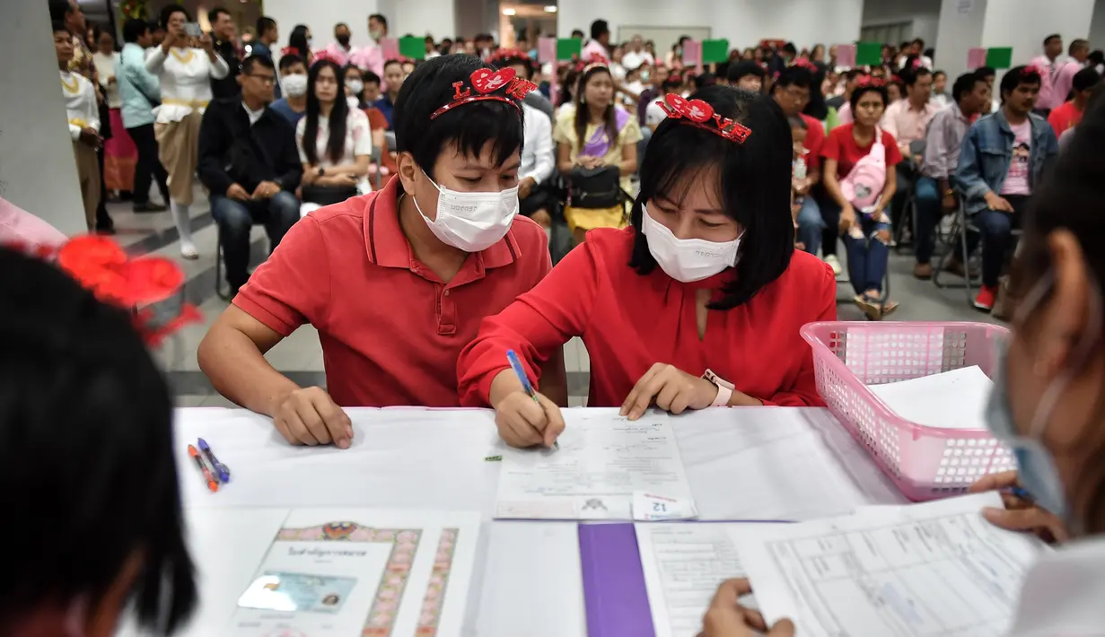 Sepasang suami istri mendaftarkan surat nikah mereka pada Hari Valentine di Bang Rak atau Distrik Cinta di Bangkok, Thailand, Jumat (14/2/2020). Banyak pasangan menikah di Distrik Cinta karena mereka percaya akan membawa keberuntungan dan cinta yang tahan lama. (Lillian SUWANRUMPHA/AFP)