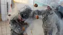 <p>Orang-orang yang bersuka ria mengenakan pakaian militer tiruan saat ikut serta dalam perang makanan "Els Enfarinats" di Kota Ibi, Spanyol, 28 Desember 2022. (JAIME REINA/AFP)</p>