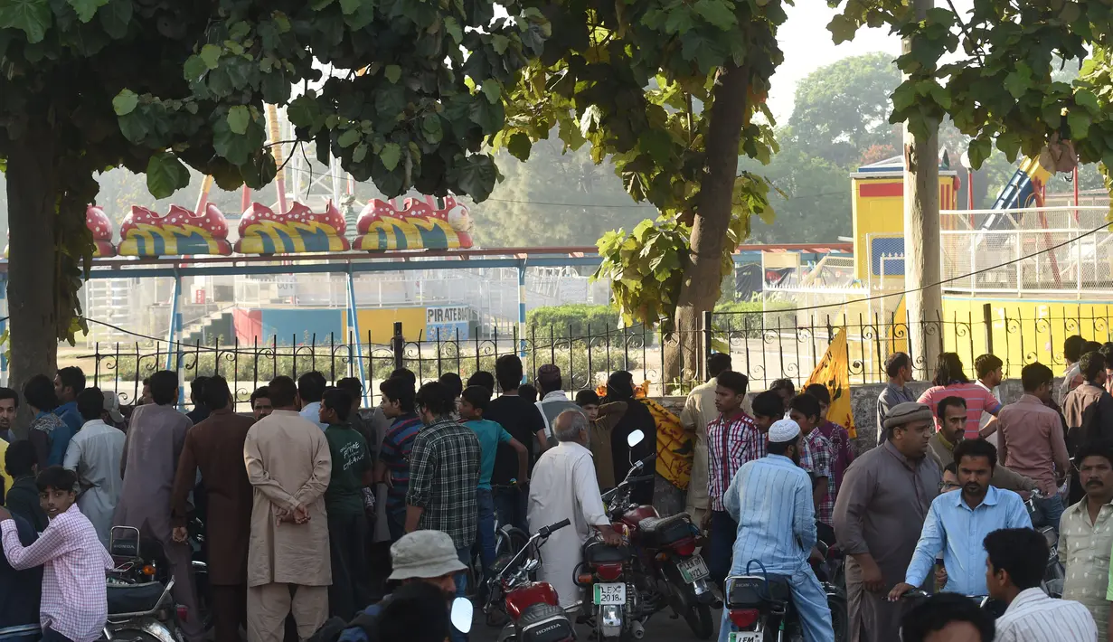 Penduduk setempat berkumpul di lokasi bom bunuh diri di taman Gulshan e Iqbal Park di Lahore, Pakistan, Senin (28/3). Korban tewas akibat ledakan bom tersebut mencapai sekitar 69 orang. (AFP/ARIF ALI)