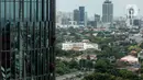Pekerja bergelantungan membersihkan bagian luar gedung di kawasan Kuningan, Jakarta, Minggu (19/12/2021). Pekerja ini harus bergelantungan dengan seutas tali untuk membersihkan dinding-dinding gedung bertingkat yang tingginya kurang lebih mencapai 150 meter. (Liputan6.com/Johan Tallo)