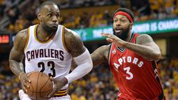 LeBron James #23 mencoba melewati hadangan pemain Toronto Raptors, James Johnson #3 pada game kedua Final wilayah Timur NBA Playoffs di  Quicken Loans Arena. Jumat (20/5/2016). Cavs menang 108-89. (Mandatory: Ken Blaze/USA Today Sports)