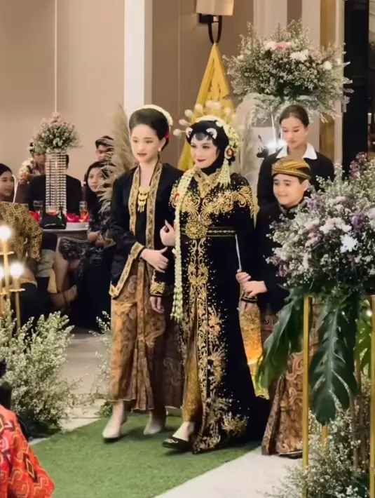 Sementara itu, Revalina tampil dengan kebaya panjang dipadukan kain batik. Lengkap dengan hiasan kepala melati dan kembang goyangnya. [@vatemat]