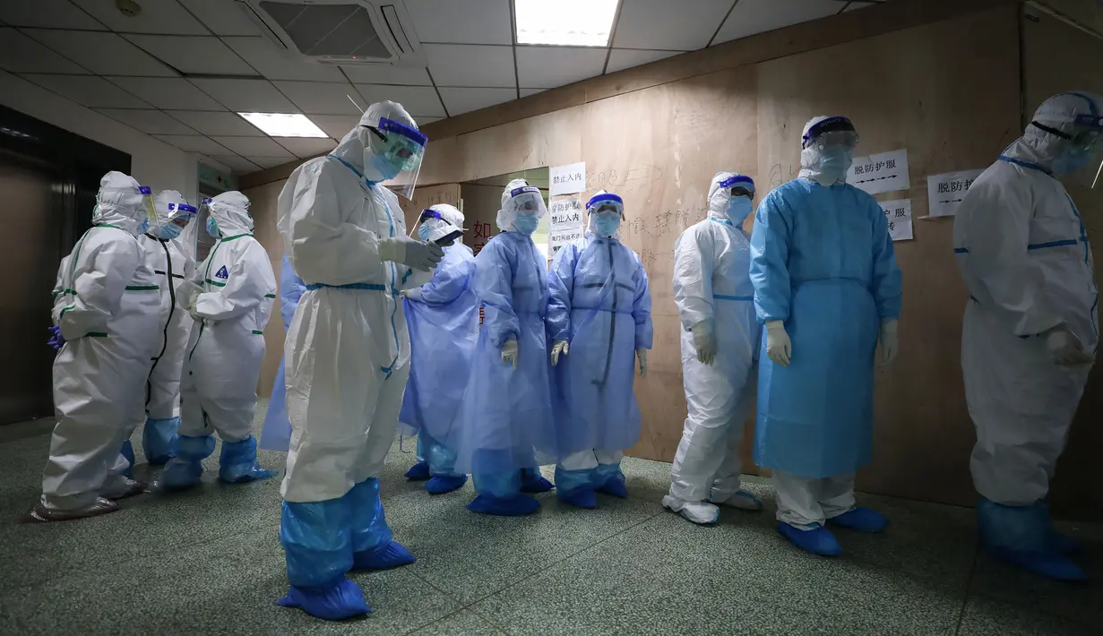 Petugas medis antre untuk melepas jas pelindung sebelum pulang kerja di Rumah Sakit Palang Merah di Wuhan pada 28 Februari 2020. Jumlah korban meninggal akibat virus corona (Covid-19) di seluruh dunia hingga Minggu (8/3) pagi sudah mencapai 3.570 orang, terbanyak masih di China. (STR/AFP)
