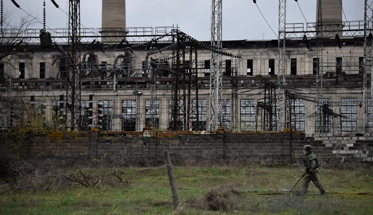 Seorang tentara Rusia menjinakkan pembangkit listrik Luhansk di kota Shchastya (13/4/2022). Pembangkit listrik Luhansk adalah pembangkit listrik termal di utara Shchastia, dekat Luhansk, Ukraina. (AFP/ Alexander Nemenov)