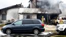 Petugas pemadam kebakaran menyemprotkan air di lokasi kecelakaan pesawat di sebuah rumah di Yorba Linda, California (3/2). Hingga kini penyebab kecelakaan masih diselidiki. (AP Photo/Alex Gallardo)