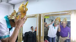 Gubernur Jawa Tengah Ganjar Pranowo (kaos putih) dan Dirut BTN Maryono (kemeja ungu) saat mencoba mahkota di ruang ganti sebelum pementasan ketoprak dengan tema Menyatukan Kembali Nusantara di GKJ, Jakarta, Minggu (21/8). (Liputan6.com/Angga Yuniar)
