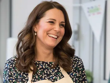 Kate Middleton tersenyum saat memasak dalam persiapan acara Commonwealth Big Lunch di Luke's Community Centre, London, Inggris (22/3). Big Lunch merupakan acara tahunan terbesar di Inggris. (Paul Edwards/ Pool via AP)