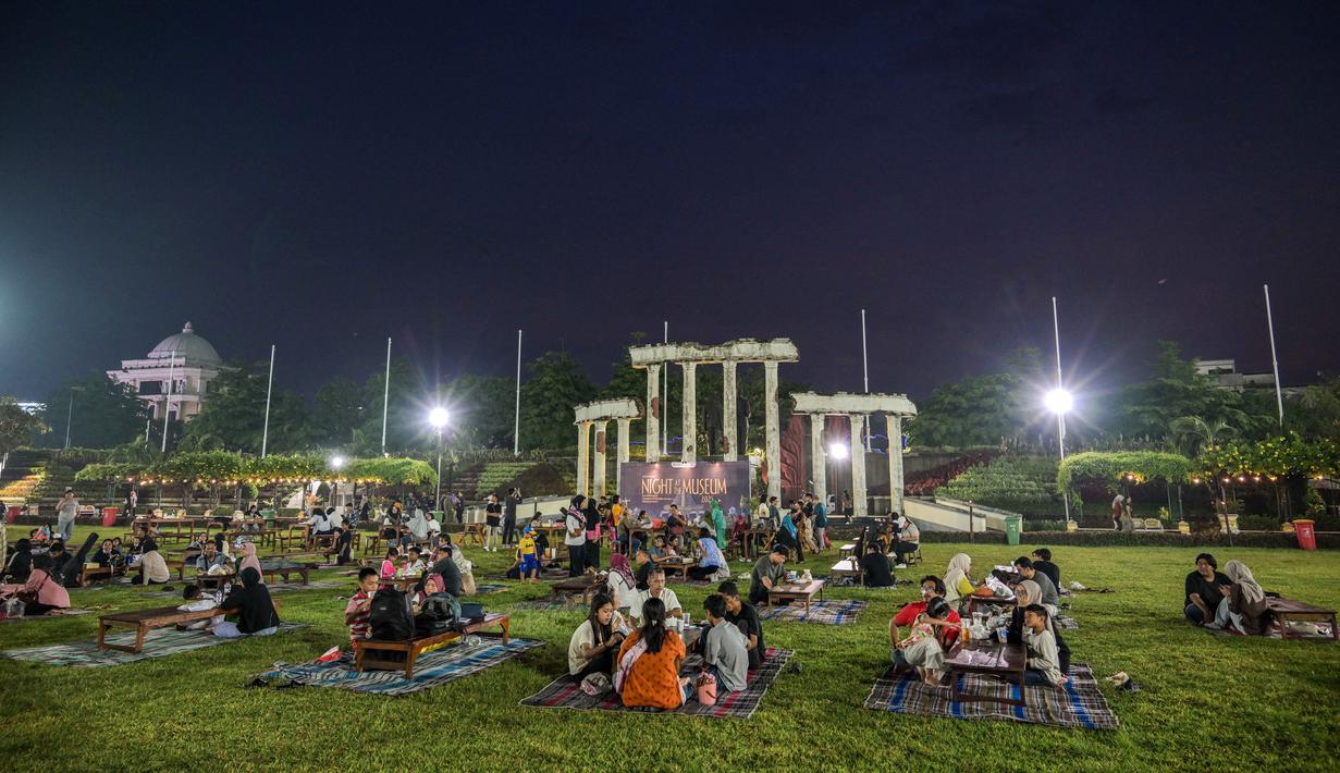 Selain menjelajahi koleksi museum dalam suasana malam, pengunjung juga dapat menikmati pertunjukan seni serta bazar Usaha Mikro Kecil dan Menengah (UMKM) di halaman Museum Tugu Pahlawan. Tampak dalam foto, masyarakat berkumpul dalam acara 'Malam di Museum 2025' di Tugu Pahlawan, dekat Museum 10 November, Surabaya, Jawa Timur, Sabtu 29 November 2025. (Juni KRISWANTO/AFP)