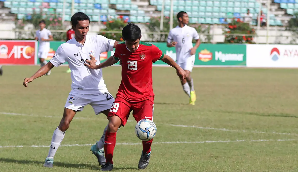 Bek Timnas Indonesia U-19, Firza Andika, berusaha melewati pemain Thailand U-19 pada laga Piala AFF U-18 di Stadion Thuwanna, Yangon, Jumat (15/9/2017). Hingga babak pertama usai skor masih imbang 0-0. (Liputan6.com/Yoppy Renato)