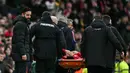 Pemain Manchester United, Lisandro Martinez ditandu keluar lapangan setelah cedera dalam laga lanjutan Liga Inggris 2024/2025 melawan Crystal Palace di Old Trafford, Manchester, Inggris, Minggu (02/02/2025). (AFP/Paul Ellis)