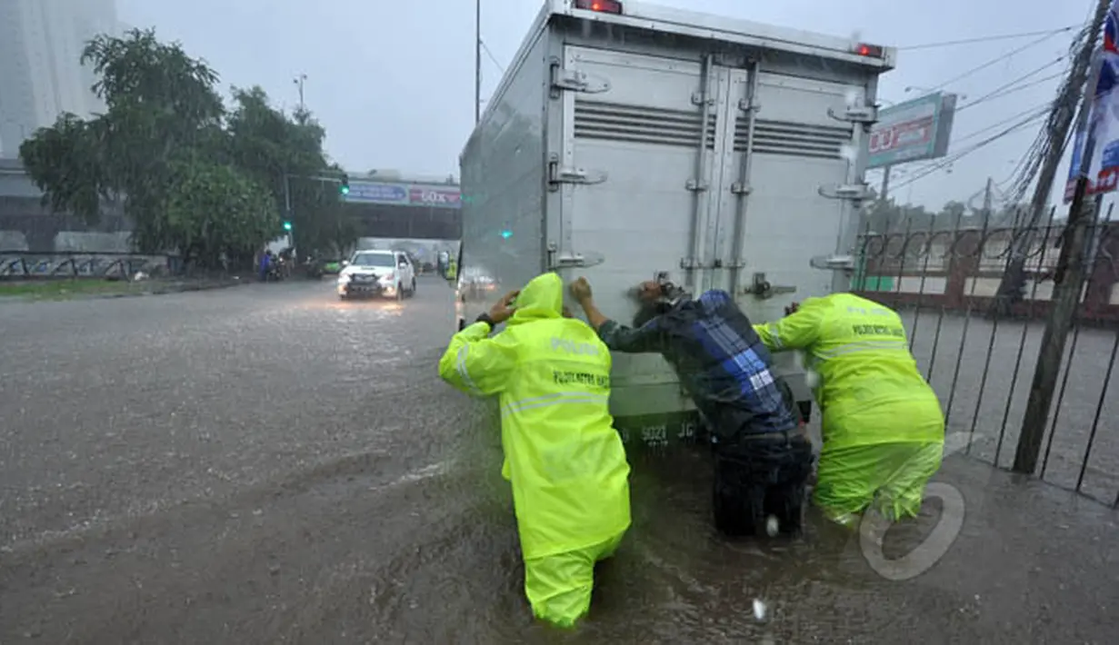 Beberapa warga terlihat mendorong sebuah mobil yang mogok di tengah banjir yang menggenangi jalan Gunung Sahari, Jakarta, Senin (9/2/2015).  (Liputan6.com/Faizal Fanani)