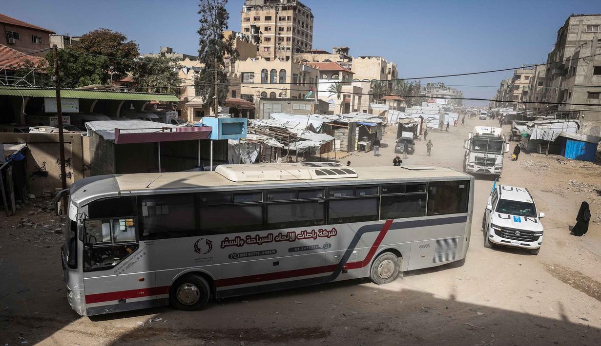 Meski telah kembali dibuka, proses penyeberangan tetap sangat ketat. Israel dilaporkan melakukan pemeriksaan keamanan penuh terhadap setiap individu yang melintas. Tampak dalam foto, konvoi yang mengangkut warga Palestina menuju penyeberangan perbatasan Rafah dengan Mesir setelah dibuka untuk pertama kalinya sejak perang AS-Israel dengan Iran dimulai, di Khan Yunis pada 19 Maret 2026. (Bashar TALEB/AFP)