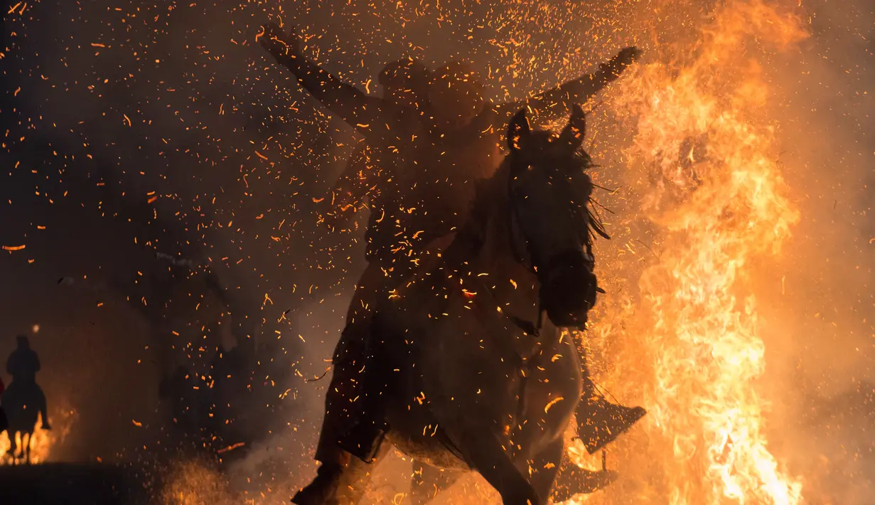 Keunikan Festival Luminarias membuat banyak turis berdatangan ke Desa San Bartolomeo de Pinares di Spanyol untuk menonton aksi menerobos api dengan kuda tersebut, Senin (16/1). (AFP Photo/ PIERRE-PHILIPPE Marcou)