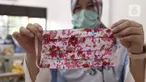 Seorang ibu memperlihatkan masker dari bahan kain yang diproduksi di Balai Latihan Kerja (BLK) Larangan, Tangerang, Senin (6/4/2020). Pemkot Tangerang memproduksi sendiri masker kain untuk didistribusikan ke wilayah Tangerang guna mencegah penyebaran virus corona Covid-19 (Liputan6.com/Angga Yuniar)