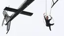 Akrobatis udara, Erendira Wallenda melambaikan tangan saat melakukan serangkaian aksi akrobatik di atas air terjun Niagara, New York, Kamis (15/6). Erendira bergelayutan di lingkaran besi yang dikaitkan pada sebuah helikopter. (AP Photo/Bill Wippert)