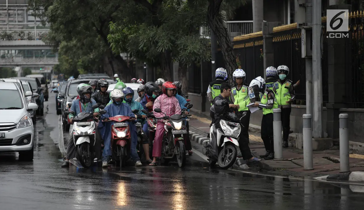 Polisi melakukan tindakan tilang kepada pengendara motor yang melanggar aturan jalur khusus di Jalan MH Thamrin, Jakarta Pusat, Kamis (8/2). Pengendara yang melanggar, ditilang dengan denda maksimal Rp 500 ribu. (Liputan6.com/Arya Manggala)