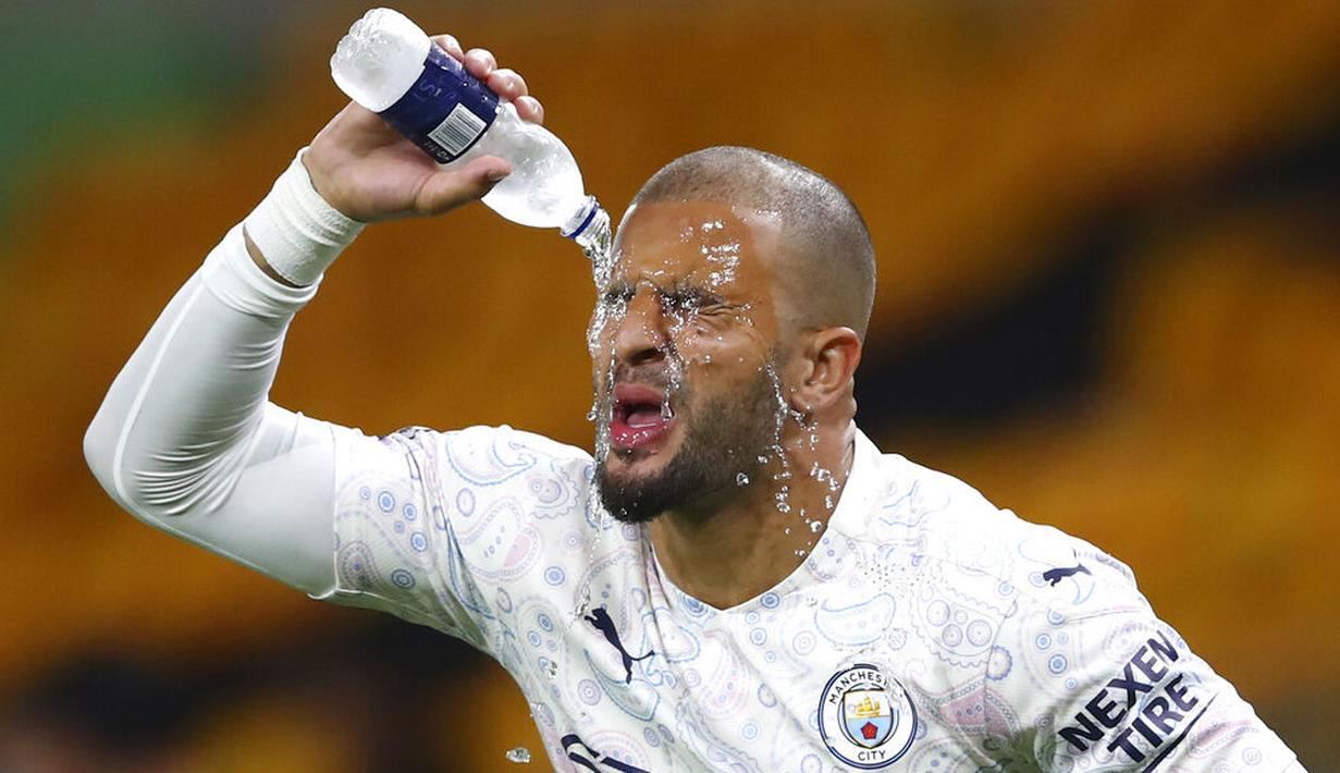 Bek Manchester City, Kyle Walker, membasahi wajahnya dengan air saat melawan Wolverhampton Wanderers pada laga Liga Inggris di Stadion Molineux, Senin (21/9/2020). Manchester City menang dengan skor 3-1. (Marc Atkins/Pool via AP)