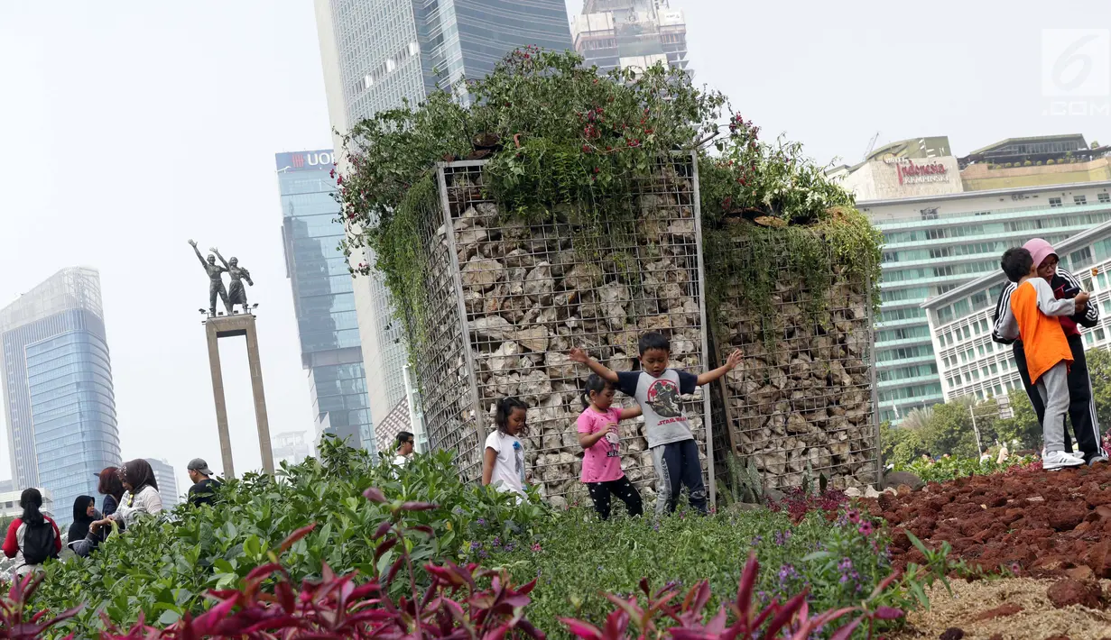 Anak-anak berjalan-jalan di area taman dekat Instalasi Gabion saat CFD di kawasan Bundaran Hotel Indonesia, Jakarta, Minggu (25/8/2019). Pengadaan Instalasi Gabion ini menggunakan Anggaran Pendapatan dan Belanja Daerah (APBD) Dinas Kehutanan DKI sebesar Rp 150 juta. (Liputan6.com/Helmi Fithriansyah)