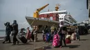 <p>Penumpang tiba di pelabuhan di Surabaya, Jawa Timur, Kamis (28/4/2022). Orang-orang melakukan perjalanan ke kota asalnya menjelang Idul Fitri yang menandai berakhirnya bulan suci Ramadhan. (Juni Kriswanto/AFP)</p>